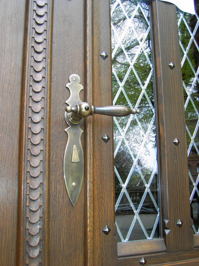 Elegancka klamka oraz rzeźbienie.